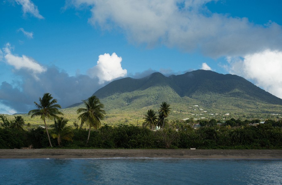 St. Kitts & Nevis. Playa con palmeras y perfil de montañas de fondo